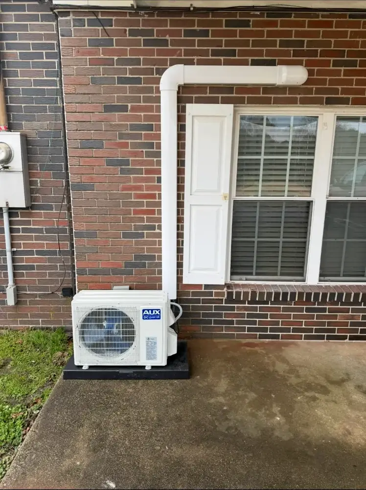 AUX DC inverter mini split outdoor unit installed beside a brick home